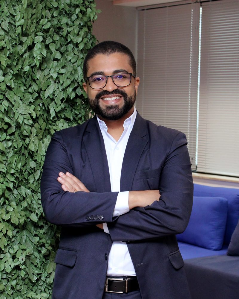 Leonardo Porto, de terno azul-marinho, de braços cruzados